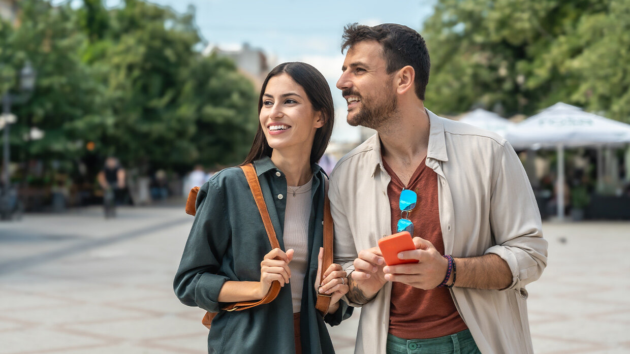 Couple de touristes dans la rue utilisant un smartphone